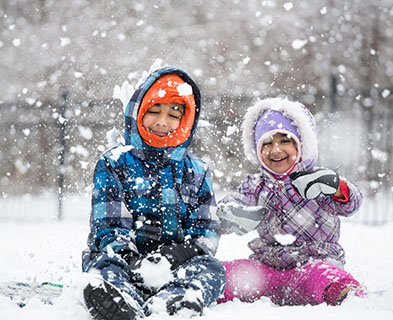 Little Children Enjoying Snowfall and Playing in the Snow