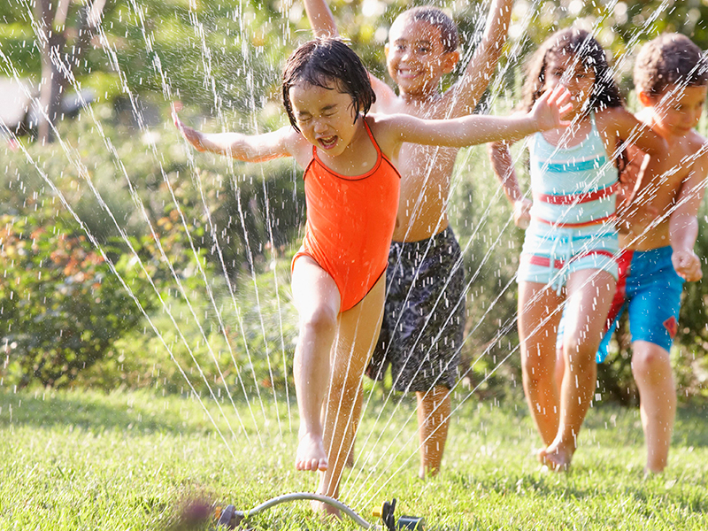 children-running-through-water-sprinkler-800